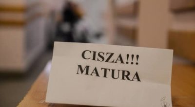 kartka z napisem "CISZA!!! MATURA" na szkolnej ławce